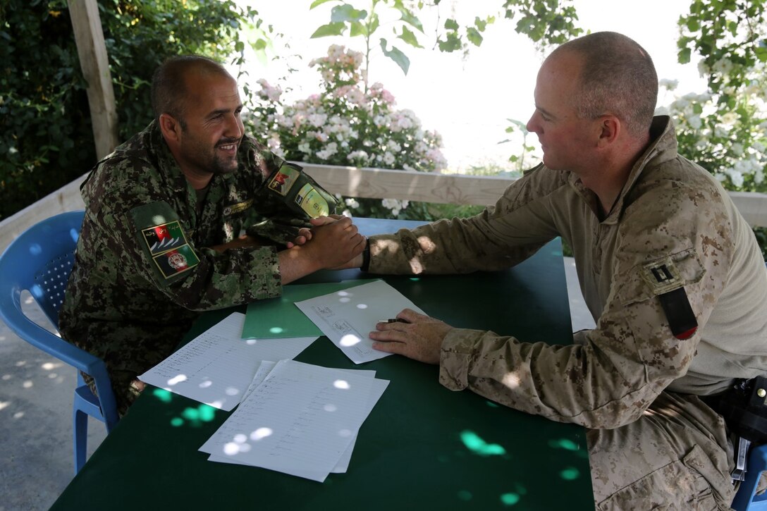 Captain Alistair Howard, commanding officer, “Suicide” Charley Company, 1st Battalion, 7th Marine Regiment, and a native of San Diego, shakes hands with an Afghan National Army soldier during their final meeting at Forward Operating Base Sabit Qadam, Afghanistan, May 4, 2014. The company turned over security responsibility of the FOB to the ANA, May 5. The infantrymen of 1st Bn., 7th Marines, were the final Marines to occupy FOB Sabit Qadam and the surrounding area in Sangin District.