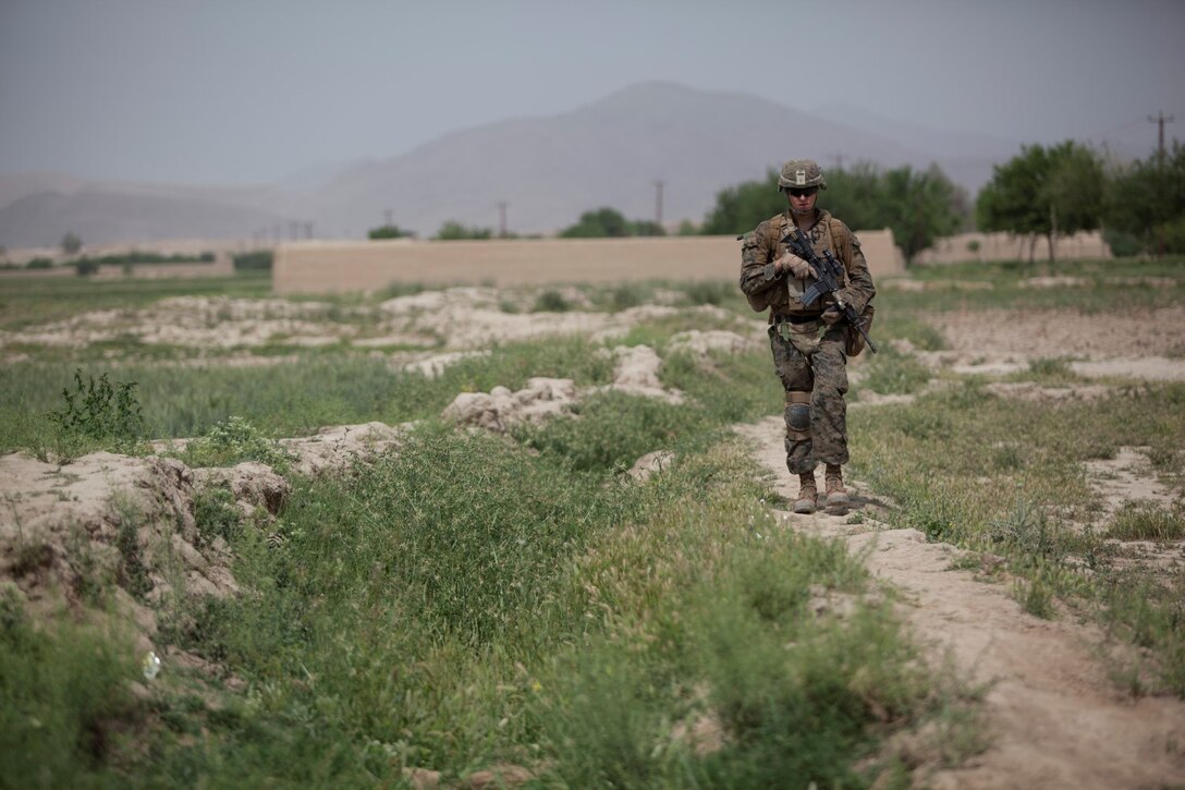 Navy Seaman Shawn Borg, corpsman, Alpha Company, 1st Battalion, 7th Marine Regiment, patrols through a field in Sangin, Afghanistan, May 8, 2012. The battalion retrograded from Sangin, May 5, 2014, and turned over security responsibility of the area to the Afghan National Army. The infantrymen of 1st Bn., 7th Marines, were the final Marines to occupy FOB Sabit Qadam and the surrounding area in Sangin District.