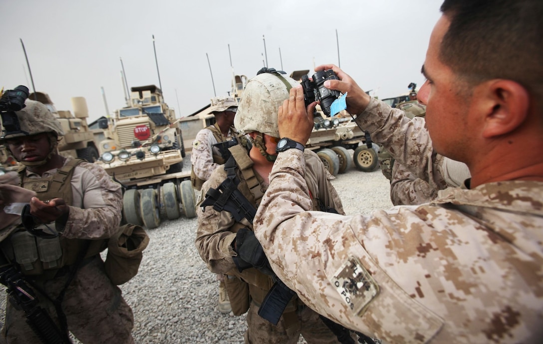A Marine with Combat Logistics Battalion 7 adjusts a PVS-14 Monocular Night Vision Device prior to a retrograde operation aboard Camp Leatherneck, Afghanistan, May 4, 2014. During the operation, Marines and sailors collected two Tractor, Rubber-Tired, Articulated Steering, Multi-Purpose vehicles and two living quarter containers from Forward Operating Base Nolay for future use aboard Camp Leatherneck.