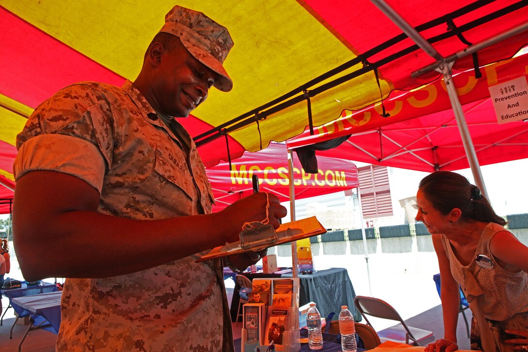 Jamil Dudley, a Nuclear, Biological, Chemical warfare specialist with CLR-1, 1st MLG, and a native of Patterson, N.J., signs up for a prevention and education course during Operation Parenthood aboard Camp Pendleton, Calif., May 1, 2014. Operation Parenthood is a one day event designed to help promote the health, well-being and safety of military families who are expecting a baby or have young children. This year, families from throughout 1st MLG participated in an event which focused on educating parents on topics like parental guidance, mood and anxiety disorders, available summer camps, daycares, life guard training, single father resources, health care, schooling and family counseling.