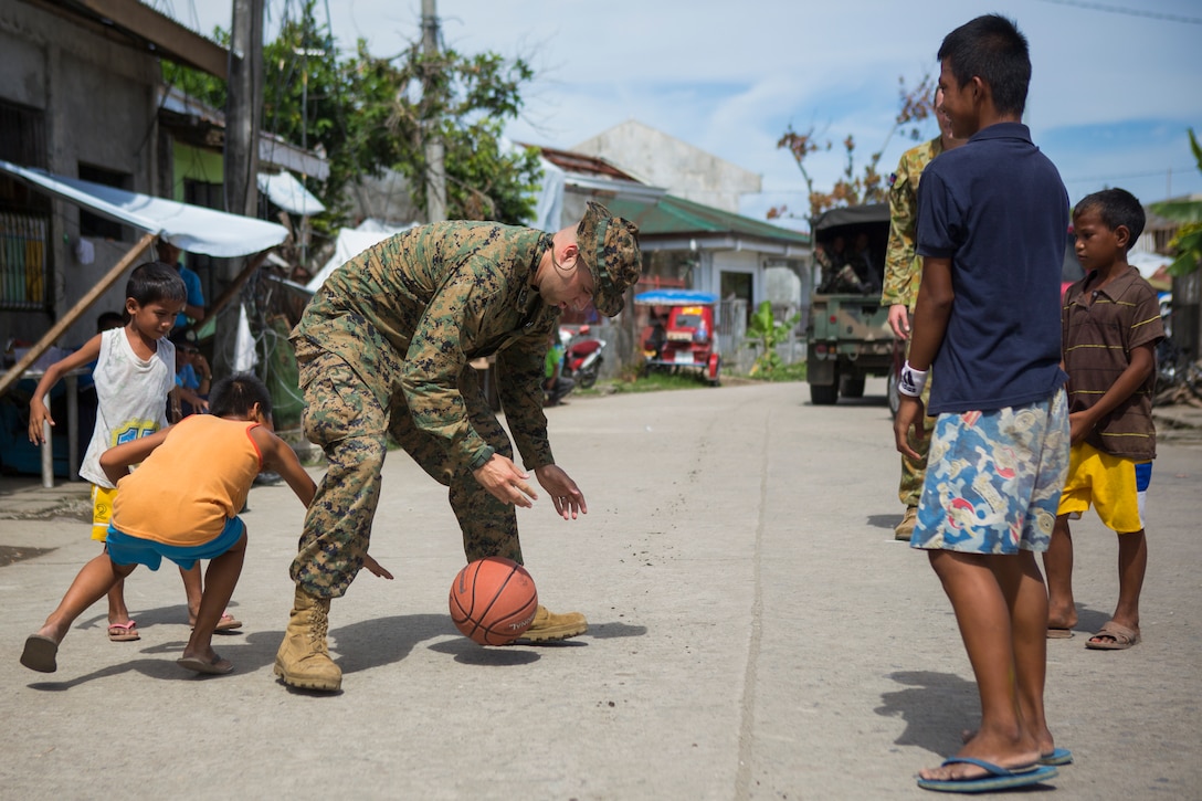 U.S. Navy HM2 Christopher Marsh, corpsman, with 1st Marine Division, stationed at Camp Pendleton, Calif., plays basketball with local Philippine children during a cooperative health engagement during Balikatan 2014 at Fishermans Village Elementary School, Tacloban, Republic of the Philippines, May 10, 2014. The Armed Forces Philippines and U.S. have had a long-standing relationship and welcome the Australian Defence Forces increasing participation in Balikatan. 