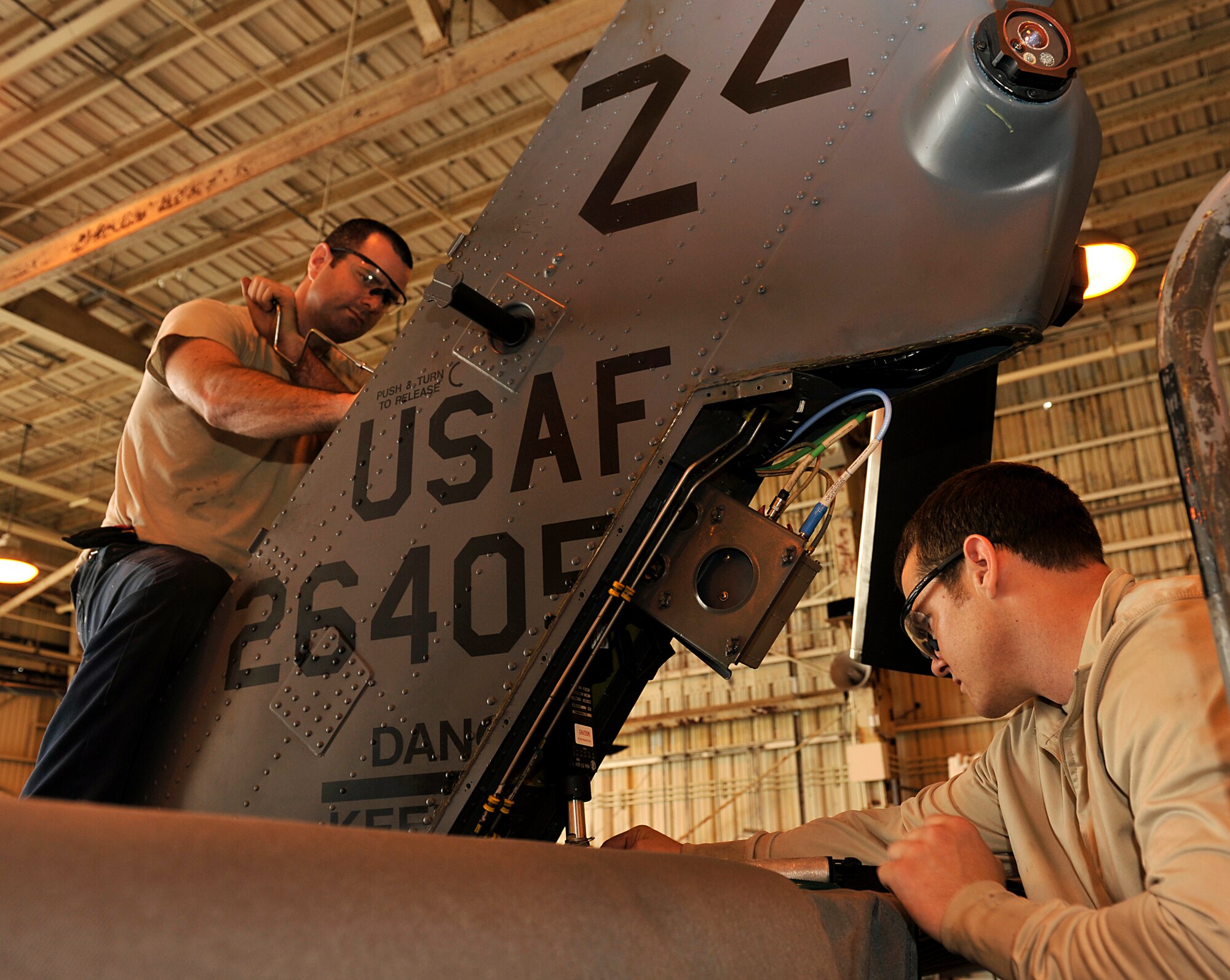 U.S. Air Force Staff Sgt. Jason Sanada (left), and Scott Passmore (right), 33rd Helicopter Maintenance Unit crew chiefs, work on a stabilizer of an HH-60G Pave Hawk helicopter during a quality assurance inspection on Kadena Air Base, Japan, May 9, 2014. The quality assurance inspection helps ensure quality of work and safety instructions are followed. (U.S. Air Force photo by Naoto Anazawa)