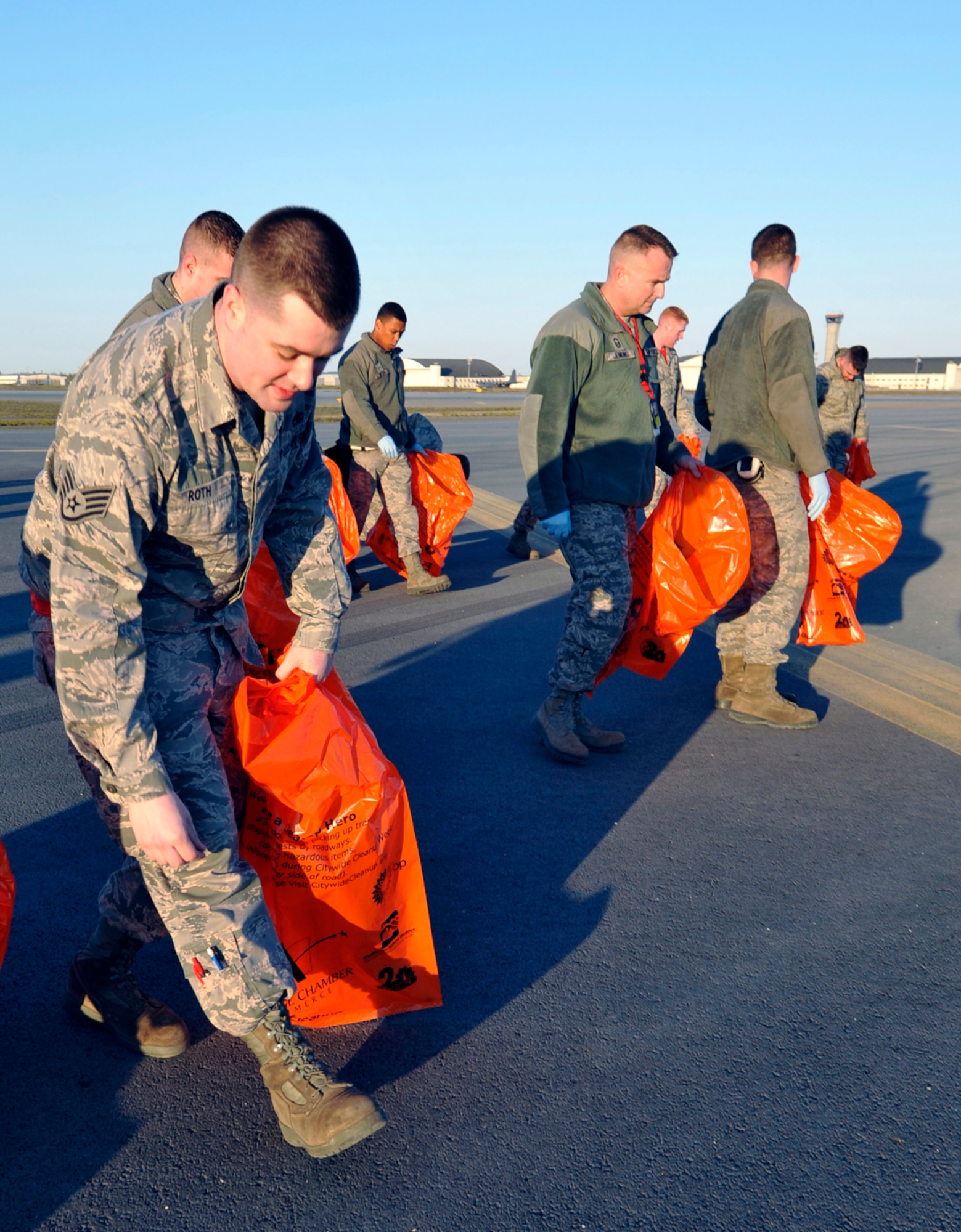 Airmen pick up trash and debris during the annual foreign object damage walk on the flight line of Joint Base Elmendorf-Richardson, Alaska, May 9, 2014. The annual FOD walk serves the dual purpose of flight line cleanup and raising awareness about the importance of controlling debris that can damage or disable aircraft. Between 88 and 1,200 pounds of trash and debris are picked up during the yearly FOD walk. (U.S. Air Force photo/Airman 1st Class Tammie Ramsouer)