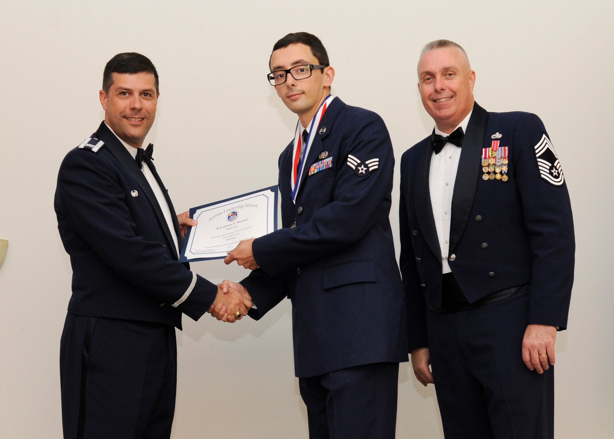 Senior Airman James Wentzel, 2nd Communications Squadron, receives an Airman Leadership School graduation certificate from Col. Andrew Gebara, 2nd Bomb Wing commander, on Barksdale Air Force Base, La., May 8, 2014. (U.S. Air Force photo/Senior Airman Joseph A. Pagán Jr.)