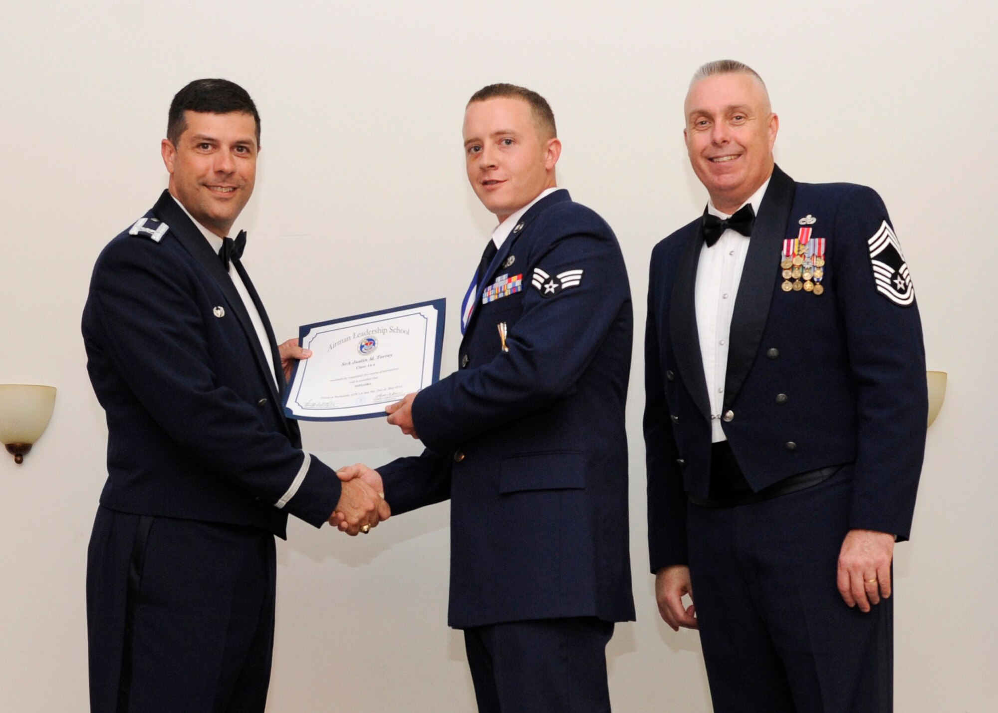 Senior Airman Justin Torrey, 2nd Aircraft Maintenance Squadron, receives an Airman Leadership School graduation certificate from Col. Andrew Gebara, 2nd Bomb Wing commander, on Barksdale Air Force Base, La., May 8, 2014. (U.S. Air Force photo/Senior Airman Joseph A. Pagán Jr.)