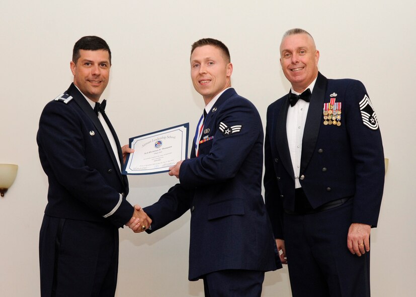 Senior Airman Khristian Thompson, 26th Operational Weather Squadron, receives an Airman Leadership School graduation certificate from Col. Andrew Gebara, 2nd Bomb Wing commander, on Barksdale Air Force Base, La., May 8, 2014. (U.S. Air Force photo/Senior Airman Joseph A. Pagán Jr.)