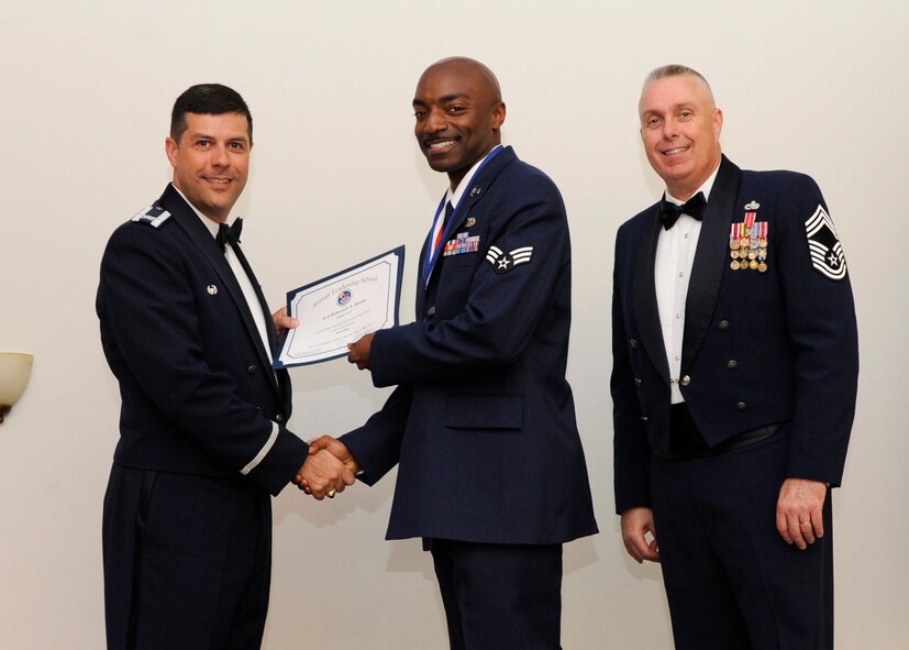 Senior Airman Roderick Rawls, 916th Maintenance Squadron, Seymour Johnson Air Forc Base, N.C., receives an Airman Leadership School graduation certificate from Col. Andrew Gebara, 2nd Bomb Wing commander, on Barksdale Air Force Base, La., May 8, 2014. (U.S. Air Force photo/Senior Airman Joseph A. Pagán Jr.)