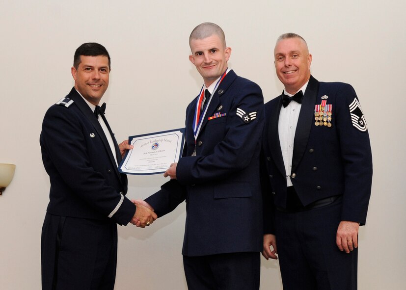 Senior Airman Samuel O’Brien, 2nd Bomb Wing Public Affairs, receives an Airman Leadership School graduation certificate from Col. Andrew Gebara, 2nd BW commander, on Barksdale Air Force Base, La., May 8, 2014. (U.S. Air Force photo/Senior Airman Joseph A. Pagán Jr.)