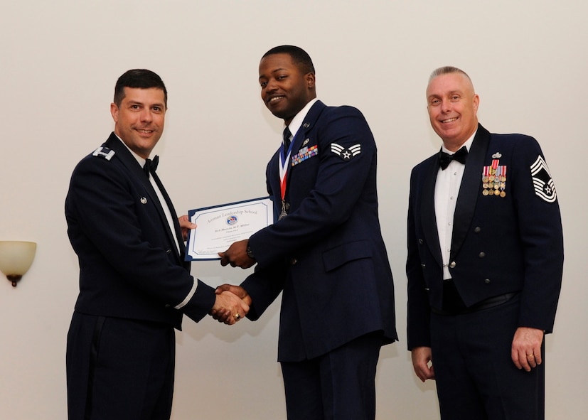 Senior Airman Marvin Miller, 2nd Logistics Readiness Squadron, receives an Airman Leadership School graduation certificate from Col. Andrew Gebara, 2nd Bomb Wing commander, on Barksdale Air Force Base, La., May 8, 2014. (U.S. Air Force photo/Senior Airman Joseph A. Pagán Jr.)