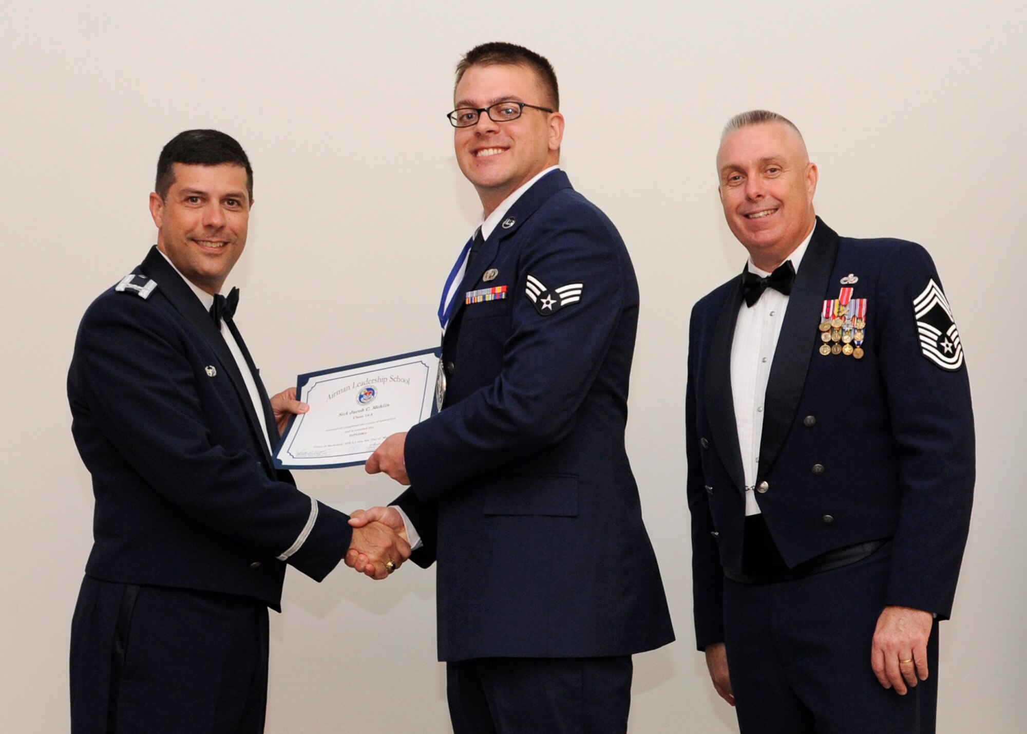 Senior Airman Jacob Mehlin, 2nd Operations Support Squadron, receives an Airman Leadership School graduation certificate from Col. Andrew Gebara, 2nd Bomb Wing commander, on Barksdale Air Force Base, La., May 8, 2014. (U.S. Air Force photo/Senior Airman Joseph A. Pagán Jr.)