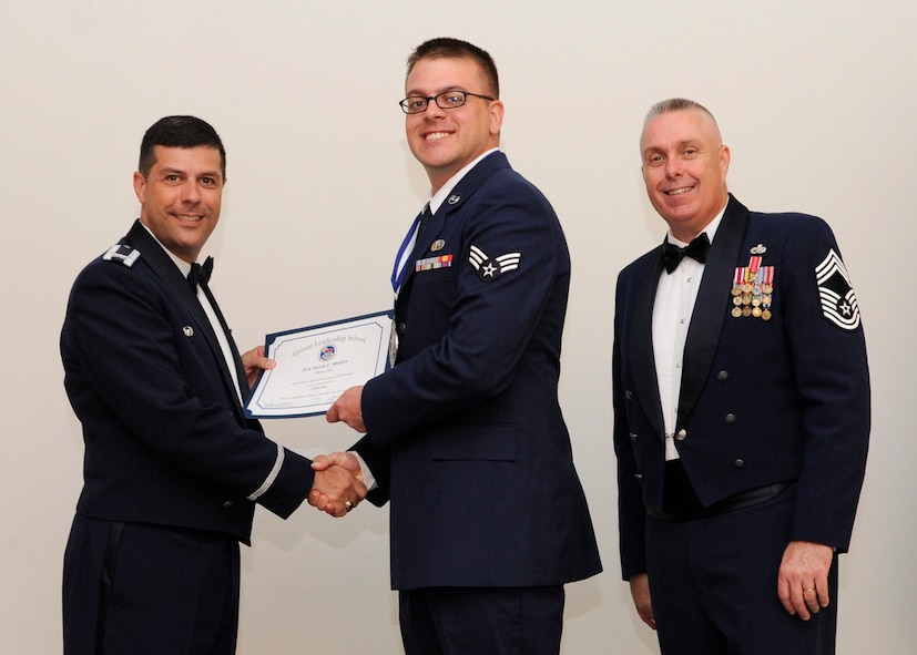 Senior Airman Jacob Mehlin, 2nd Operations Support Squadron, receives an Airman Leadership School graduation certificate from Col. Andrew Gebara, 2nd Bomb Wing commander, on Barksdale Air Force Base, La., May 8, 2014. (U.S. Air Force photo/Senior Airman Joseph A. Pagán Jr.)