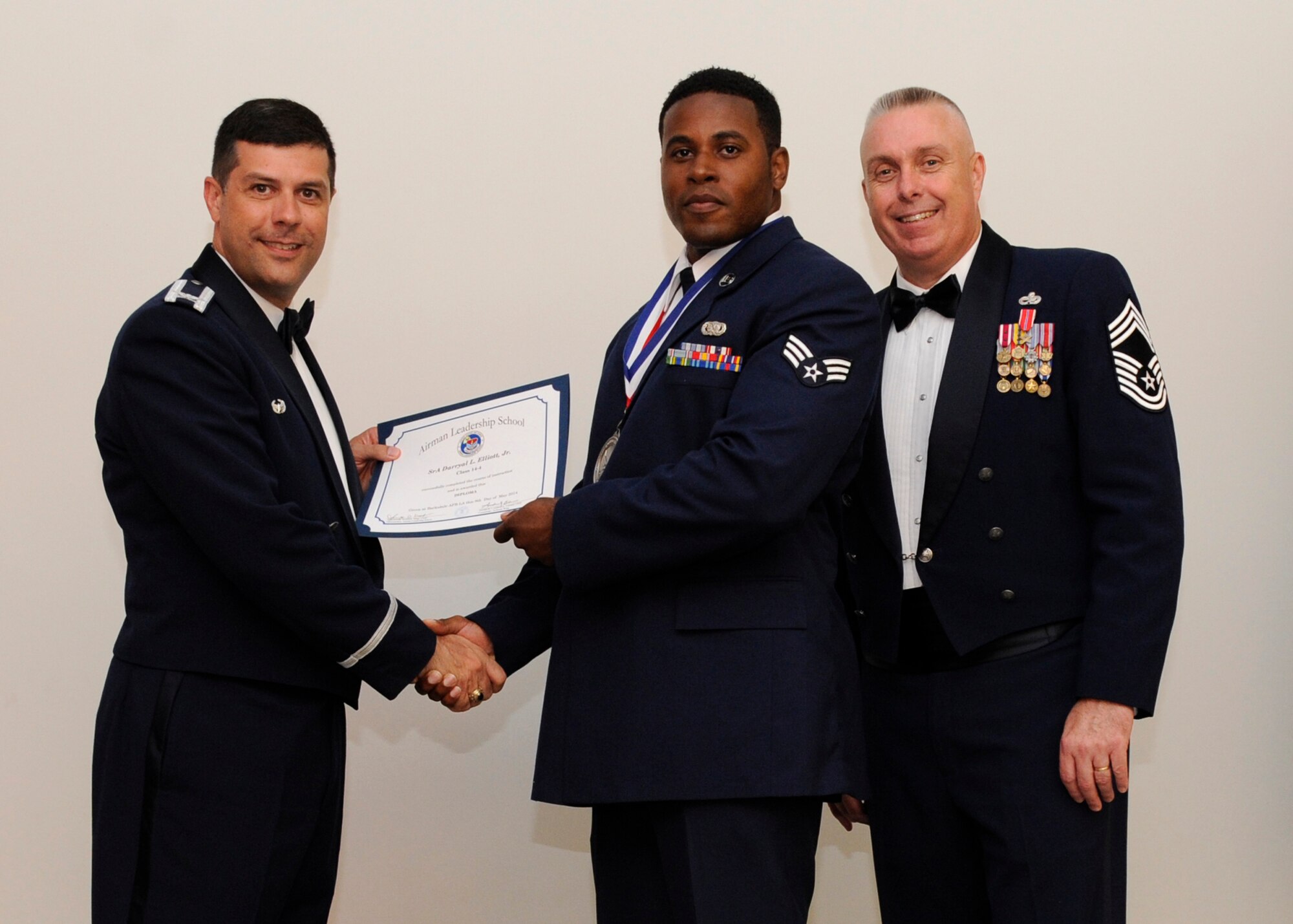 Senior Airman Darryal Elliott Jr., 2nd Logistics Readiness Squadron, receives an Airman Leadership School graduation certificate from Col. Andrew Gebara, 2nd Bomb Wing commander, on Barksdale Air Force Base, La., May 8, 2014. (U.S. Air Force photo/Senior Airman Joseph A. Pagán Jr.)