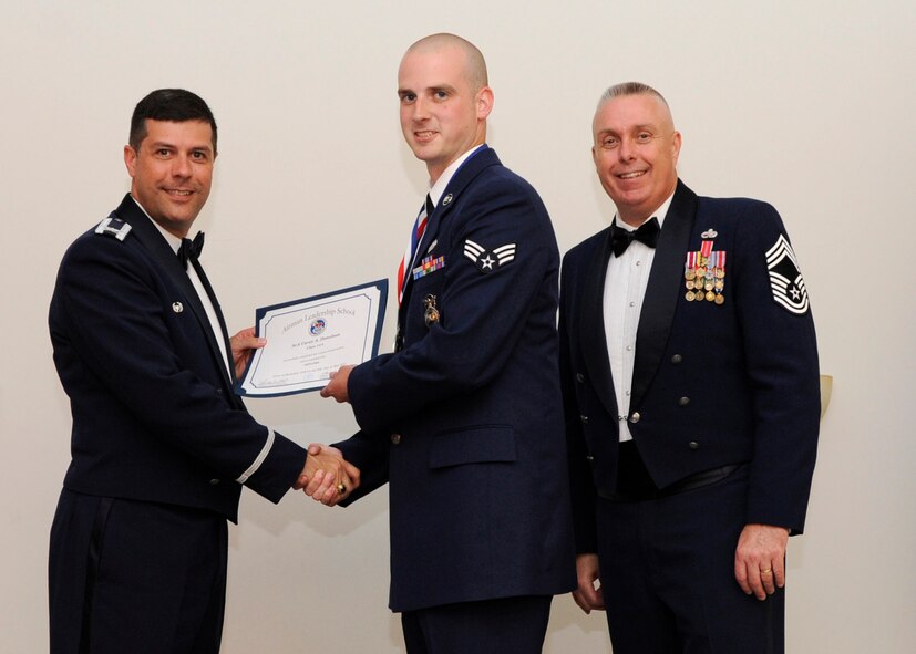 Senior Airman Corey Donelson, 2nd Security Forces Squadron, receives an Airman Leadership School graduation certificate from Col. Andrew Gebara, 2nd Bomb Wing commander, on Barksdale Air Force Base, La., May 8, 2014. (U.S. Air Force photo/Senior Airman Joseph A. Pagán Jr.)