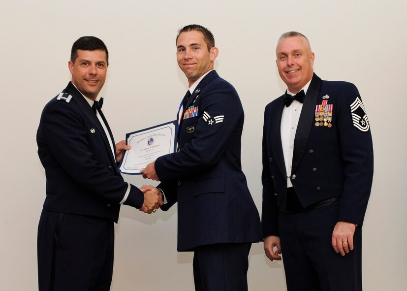 Staff Sgt. Jason Buettner, 20th Air Support Squadron Detachment 1, Fort Polk, La., receives an Airman Leadership School graduation certificate from Col. Andrew Gebara, 2nd Bomb Wing commander, on Barksdale Air Force Base, La., May 8, 2014. (U.S. Air Force photo/Senior Airman Joseph A. Pagán Jr.)