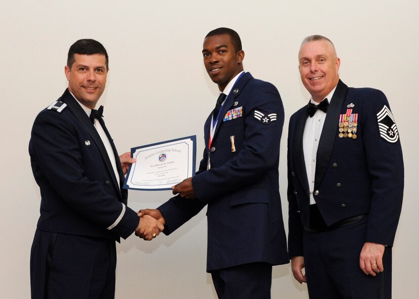 Senior Airman Marvin Tookes, 2nd Aircraft Maintenance Squadron, receives an Airman Leadership School graduation certificate from Col. Andrew Gebara, 2nd Bomb Wing commander, on Barksdale Air Force Base, La., May 8, 2014. (U.S. Air Force photo/Senior Airman Joseph A. Pagán Jr.)