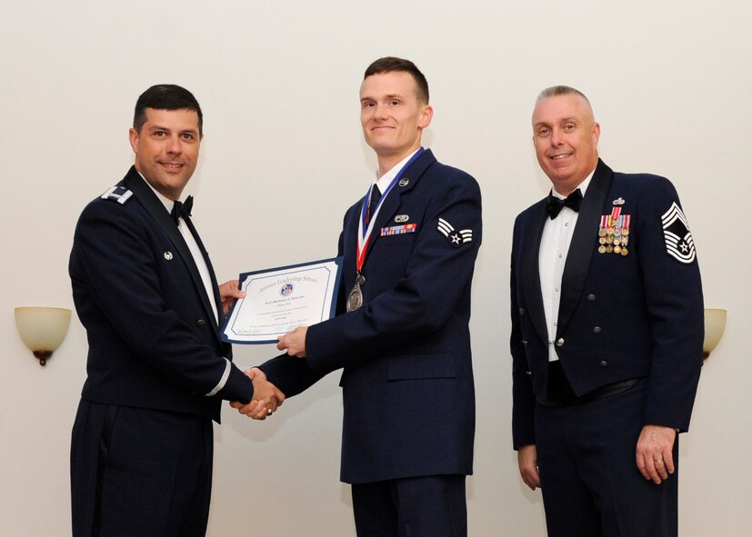 Senior Airman Michael Saucier, 2nd Munitions Squadron, receives an Airman Leadership School graduation certificate from Col. Andrew Gebara, 2nd Bomb Wing commander, on Barksdale Air Force Base, La., May 8, 2014. (U.S. Air Force photo/Senior Airman Joseph A. Pagán Jr.)