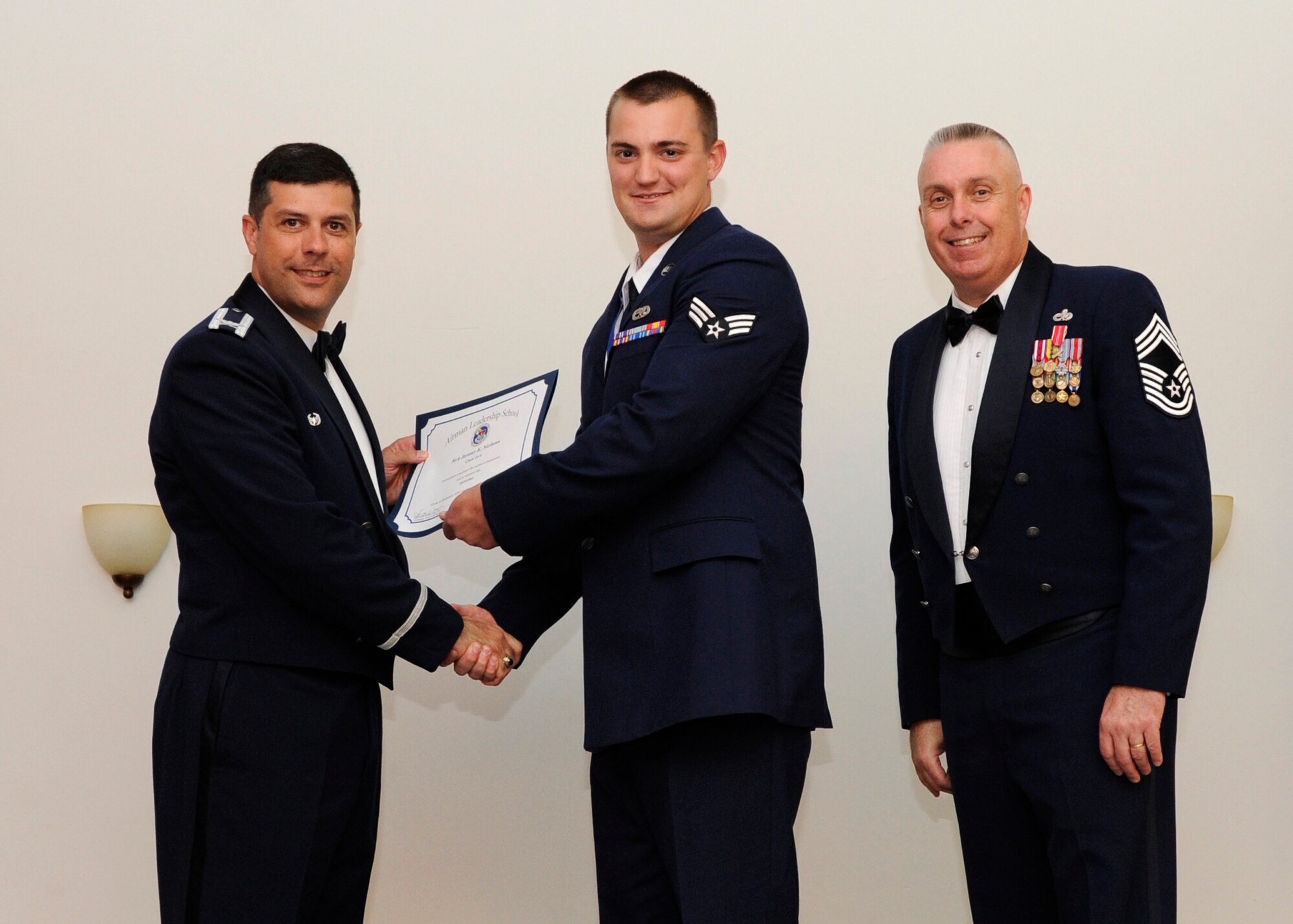Senior Airman Jeremy Nickens, 2nd Maintenance Squadron, receives an Airman Leadership School graduation certificate from Col. Andrew Gebara, 2nd Bomb Wing commander, on Barksdale Air Force Base, La., May 8, 2014. (U.S. Air Force photo/Senior Airman Joseph A. Pagán Jr.)