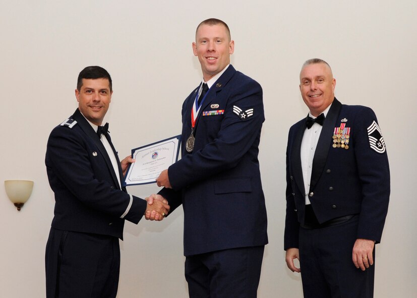Senior Airman Benjamin Follansbee, 2nd Munitions Squadron, receives an Airman Leadership School graduation certificate from Col. Andrew Gebara, 2nd Bomb Wing commander, on Barksdale Air Force Base, La., May 8, 2014. (U.S. Air Force photo/Senior Airman Joseph A. Pagán Jr.)