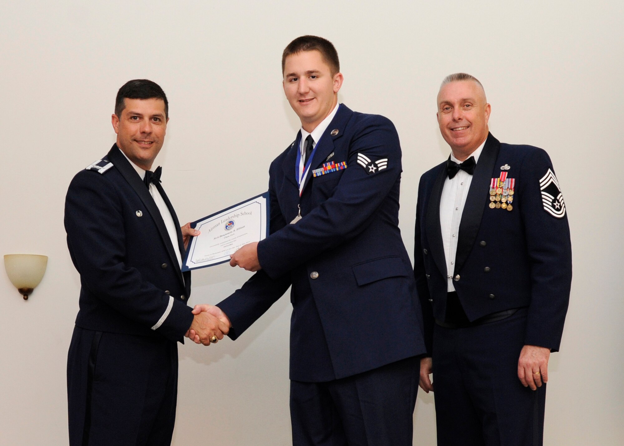 Senior Airman Benjamin Elliott, 2nd Aircraft Maintenance Squadron, receives an Airman Leadership School graduation certificate from Col. Andrew Gebara, 2nd Bomb Wing commander, on Barksdale Air Force Base, La., May 8, 2014. (U.S. Air Force photo/Senior Airman Joseph A. Pagán Jr.)