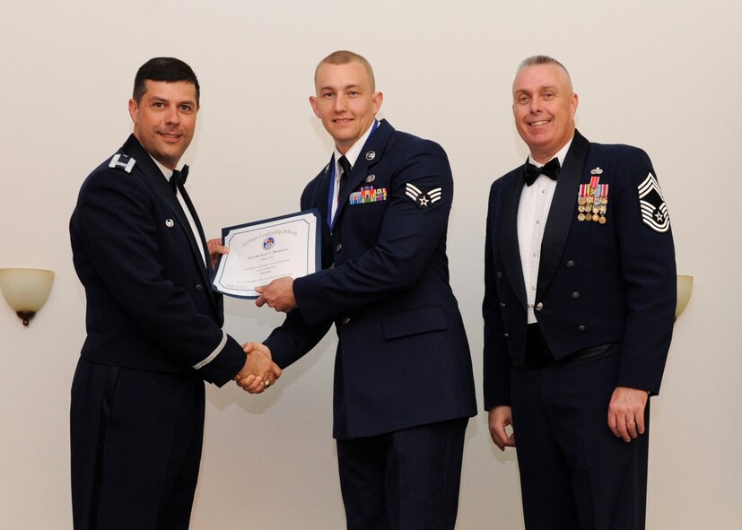 Senior Airman Michael Dormeier, 2nd Communications Squadron, receives an Airman Leadership School graduation certificate from Col. Andrew Gebara, 2nd Bomb Wing commander, on Barksdale Air Force Base, La., May 8, 2014. (U.S. Air Force photo/Senior Airman Joseph A. Pagán Jr.)