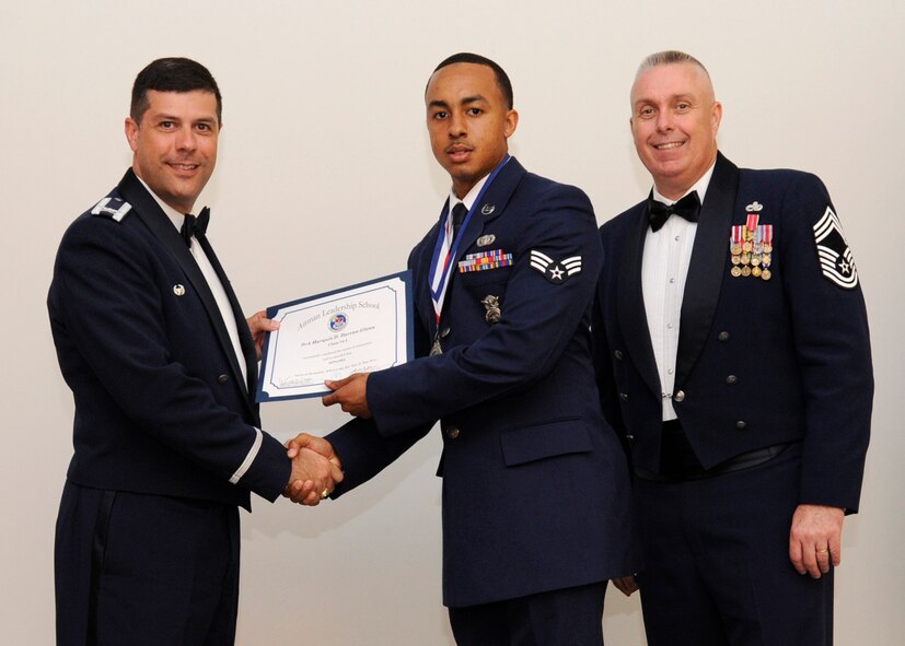 Senior Airman Marquis Barron-Glenn, 2nd Security Forces Squadron, receives an Airman Leadership School graduation certificate from Col. Andrew Gebara, 2nd Bomb Wing commander, on Barksdale Air Force Base, La., May 8, 2014. (U.S. Air Force photo/Senior Airman Joseph A. Pagán Jr.)