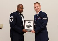 Senior Airman Austin Groupp, 2nd Maintenance Squadron, receives the John Levitow Award from Chief Master Sgt. Jeffrey Smith, 608th Air Operations Center, during the Airman Leadership School Class 14-4 Graduation on Barksdale Air Force Base, La., May 8, 2014. (U.S. Air Force photo/Senior Airman Joseph A. Pagán Jr.)