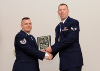 Senior Airman Benjamin Follansbee, 2nd Munitions Squadron, receives the Distinguished Graduate Award from Tech. Sgt. Troy Hartman, 2nd Maintenance Squadron, on behalf of the Air Force Sergeants Association during the Airman Leadership School class 14-4 graduation on Barksdale Air Force Base, La., May 8, 2014. (U.S. Air Force photo/Senior Airman Joseph A. Pagán Jr.)