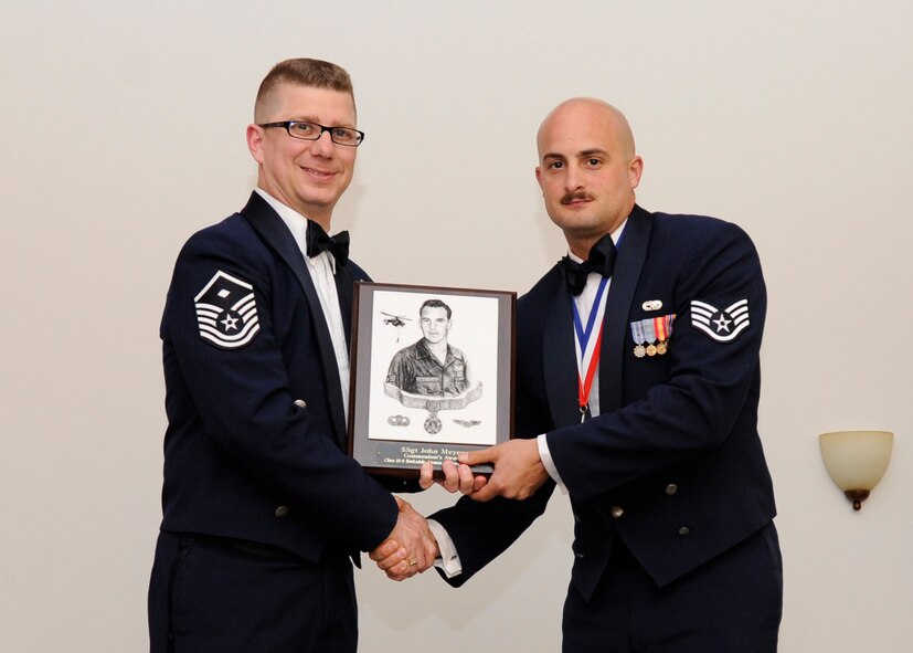 Staff Sgt. John Meyer Jr., 2nd Aircraft Maintenance Squadron, receives the Commandant's Award from Master Sgt. Chad Kraus, 2nd Operations Group first sergeant, during the Airman Leadership School class 14-4 Graduation on Barksdale Air Force Base, La., May 8, 2014. (U.S. Air Force photo/Senior Airman Joseph A. Pagán Jr.)