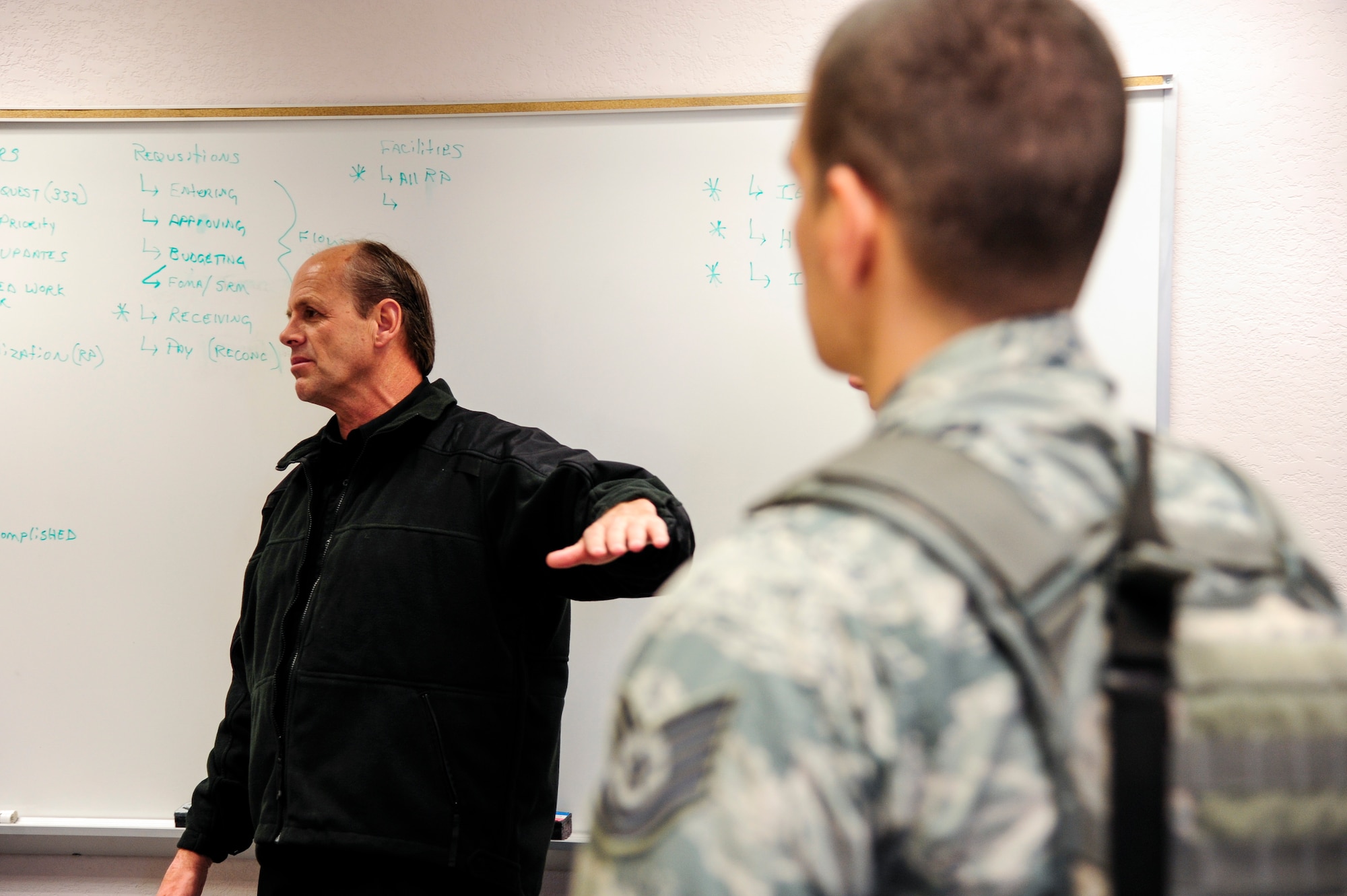 Jon Mulcahy, a trainer with Analytic Services Inc., discusses the outcome of an active shooter scenario with 354th Security Forces Squadron Airmen May 8, 2014, Eielson Air Force Base, Alaska. Mulcahy and his team trained defenders on high-risk response with real-life scenarios and role players. (U.S. Air Force photo by Senior Airman Zachary Perras/Released)