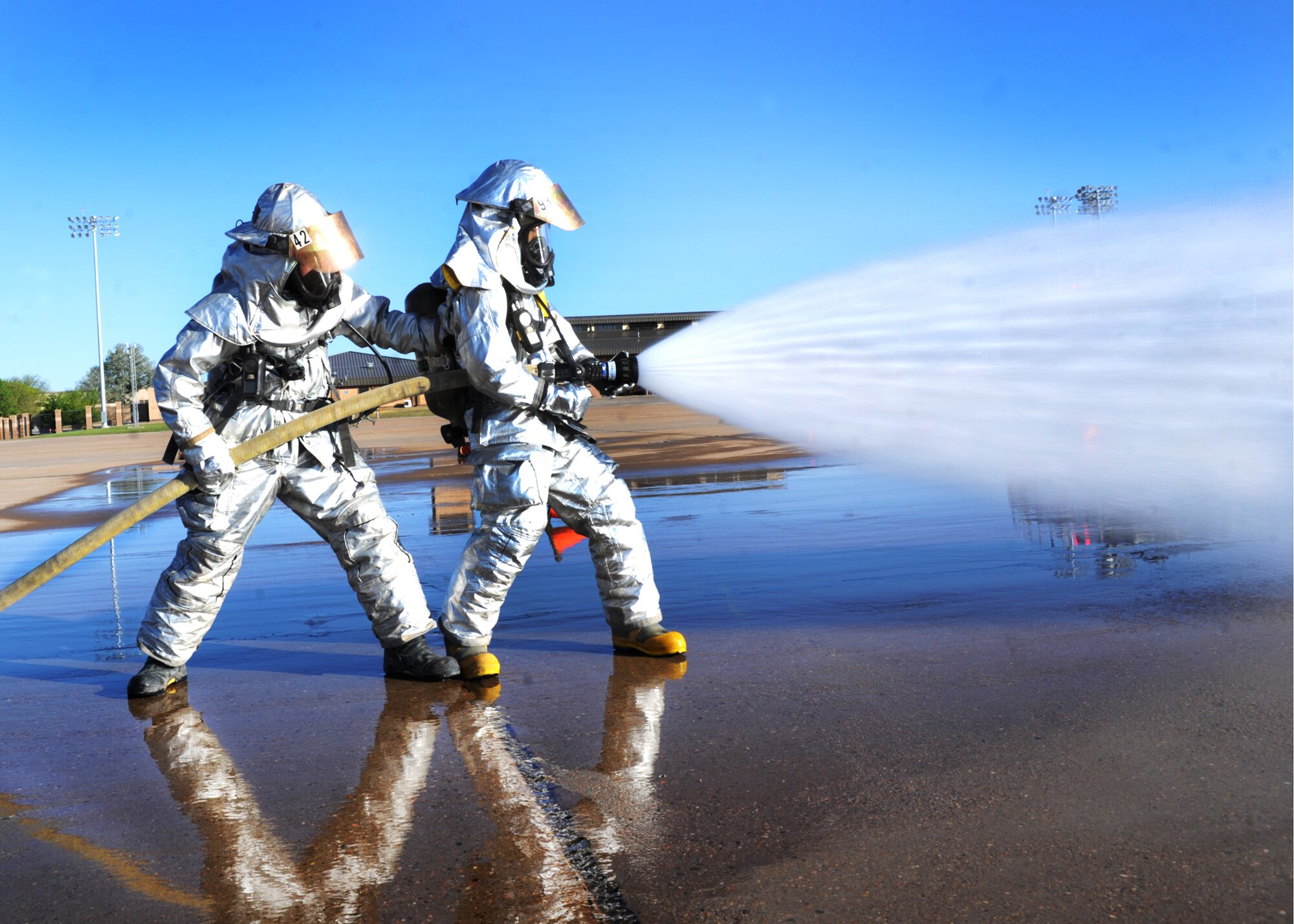 Two members of the 27th Special Operations Civil Engineer Squadron hose down a simulated aircraft fire during an exercise May 6, 2014 at Cannon Air Force Base N.M. The exercise was designed to enhance Cannon’s preparedness and safety prior to the air show which is scheduled to take place May 24 and 25. (U.S. Air Force photo/Senior Airman Ericka Engblom)