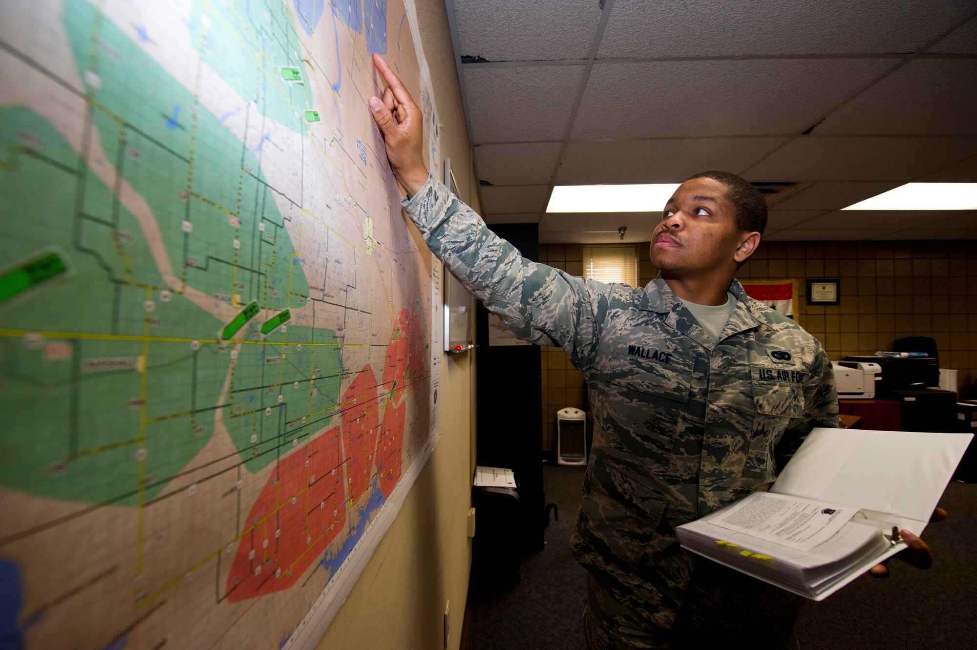Staff Sgt. David Wallace III, 91st Security Forces Group plans and programs section, identifies possible threats and hazards to security force teams within the missile complex along, with crafting tactical defense plans for launch facilities and missile alert facilities at Minot Air Force Base, N.D., May 12, 2014. Wallace was named one of the 12 Outstanding Airmen of the Year. (U.S. Air Force photo/Senior Airman Brittany Y. Auld)
