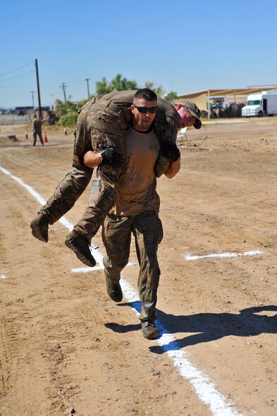 Staff Sgt. Derrick Lehner, 944th Fighter Wing chaplain assistant, carries a member of his team during the EOD PT challenge at Luke. Lehner was a member of a four-person team competing for best time through the obstacle course. (U.S. Air Force photo/Senior Airman Jason Colbert)