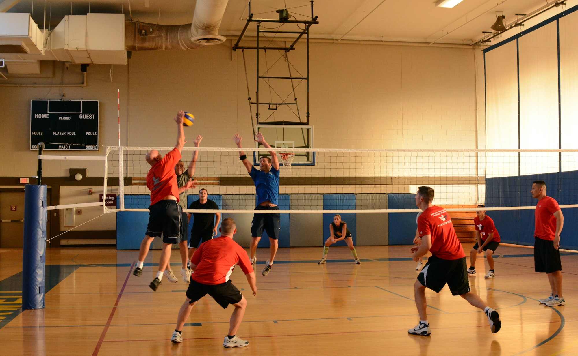 Col. Wayne Straw, Squadron Officer College,( in red) spikes the ball past  Maj. Greg Preisser (in grey) Maj. Eric Fleming (in blue), both from the Air Command and Staff College during the 2014 Maxwell-Gunter Air Force Base intramural volleyball championship, May 6, 2014. The intramural league is designed to help build cohesion and improve morale within units and among service members on base. (U.S. Air Force Photo by Staff Sgt. Gregory Brook)
