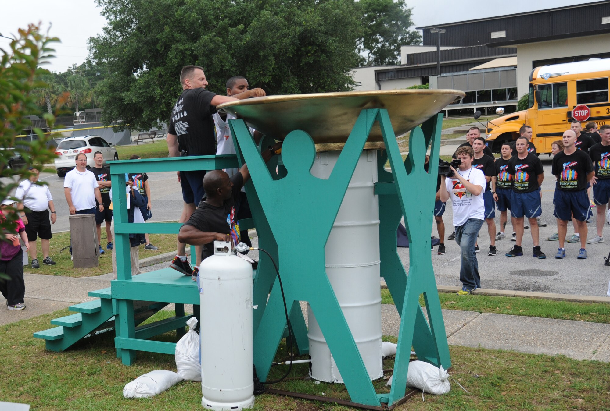 Brig. Gen. Patrick Higby, 81st Training Wing commander, and Rasaan Grear, athlete, light the cauldron following the Mississippi's Special Olympics Law Enforcement Torch Run May 9, 2014.The torch was carried through 21 communities by more than 100 state law enforcement agencies. This is the 28th year Keesler has hosted the state Special Olympics. (U.S. Air Force photo by Kemberly Groue)