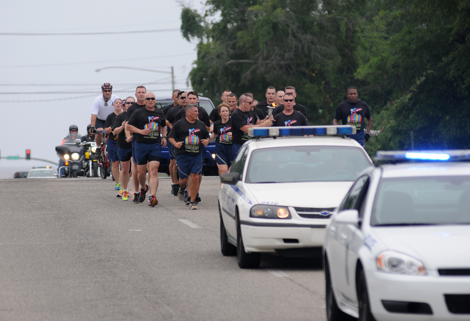 Members of the 81st Security Forces Squadron make their way into Keesler Air Force Base, Miss., as they prepare to pass the torch onto Brig. Gen. Patrick Higby, 81st Training Wing commander, for the final link in Mississippi's Special Olympics Law Enforcement Torch Run May 9, 2014. The torch was carried through 21 communities by more than 100 state law enforcement agencies. This is the 28th year Keesler has hosted the state Special Olympics. (U.S. Air Force photo by Kemberly Groue)