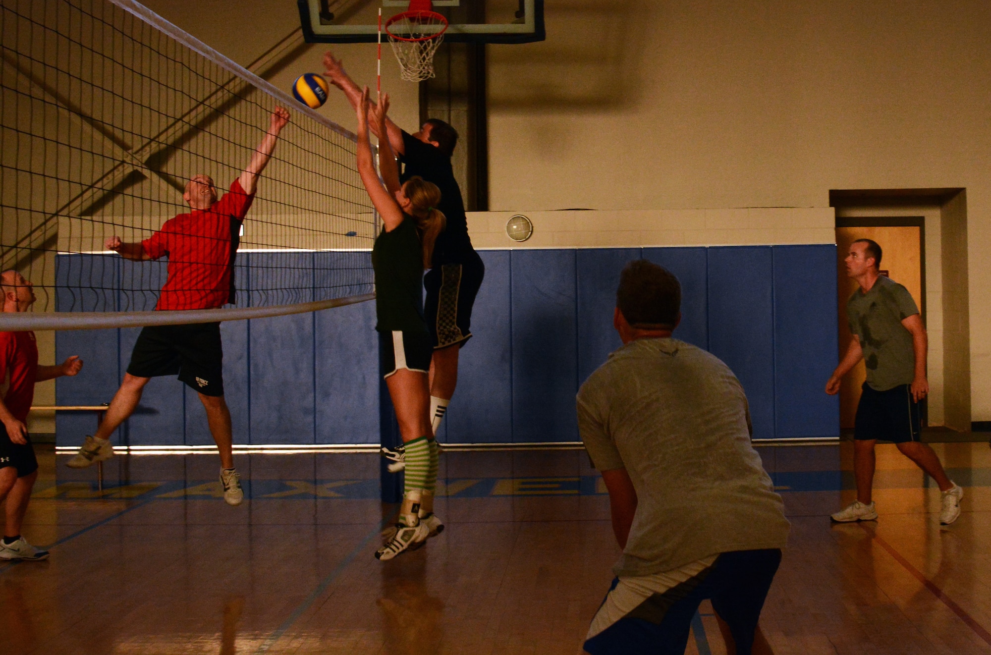 Master Sgt. Robert Vensel (in red), Squadron Officer College, Punches the ball, blocking a spike by members of the Air Command and Staff College team during the 2014 Maxwell-Gunter Air Force Base intramural volleyball championship, May 6, 2014. The intramural league is designed to help build cohesion and improve morale within units and among service members on base. (U.S. Air Force Photo by Staff Sgt. Gregory Brook)