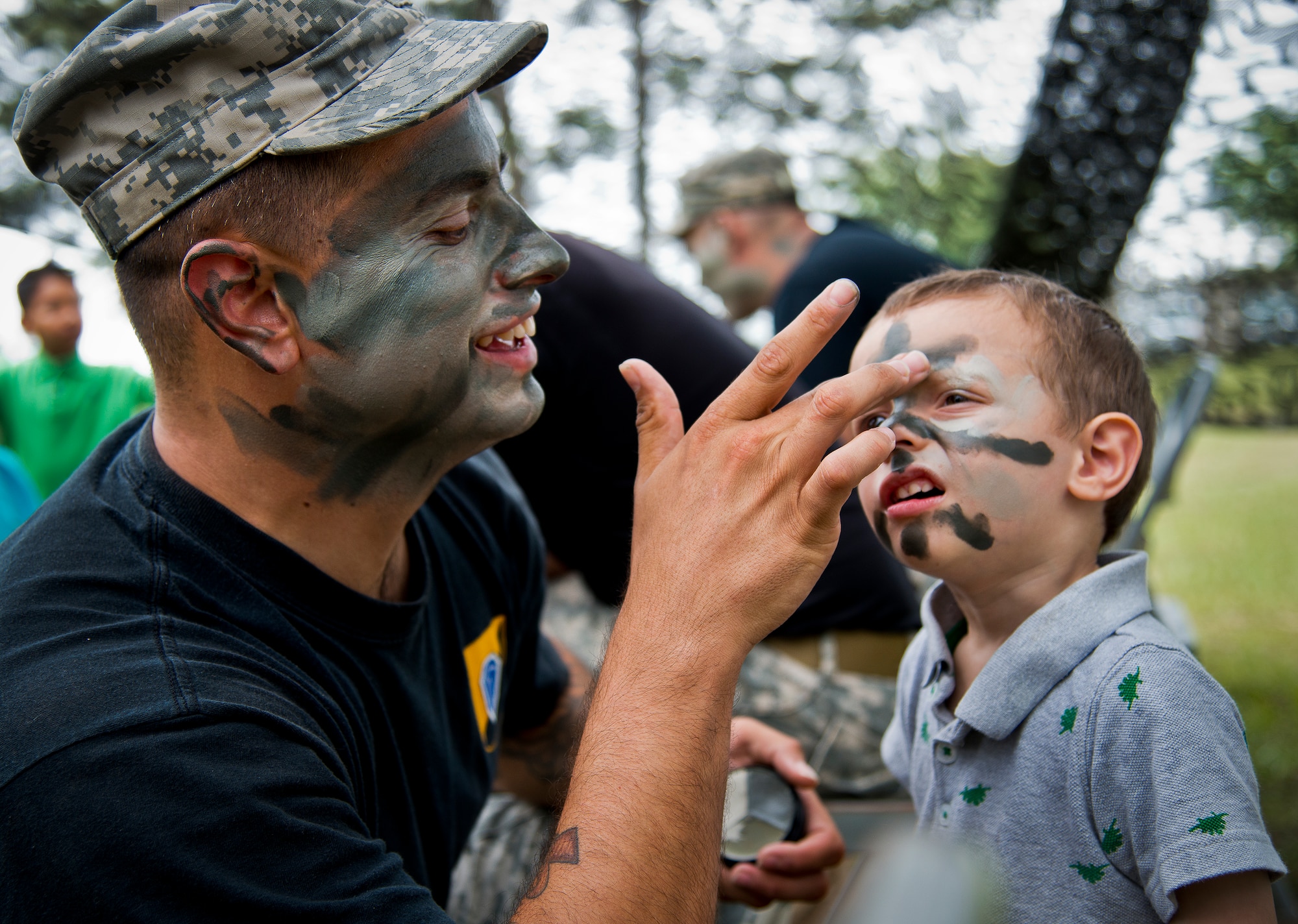 Spc. Youngs applies Ranger camouflage paint to two-year-old “soldier in training,” Miles Byrd, at the face-painting booth during the 6th Ranger Training Battalion’s Open House event May 10 at Eglin Air Force Base, Fla.  The event was a chance for the public to learn how Rangers train and operate. The event displays showed equipment, weapons, a reptile zoo, face painting and weapon firing among others. The demonstrations showed off hand-to-hand combat, a parachute jump, snake show, and Rangers in action.  (U.S. Air Force photo/Tech. Sgt. Sam King)