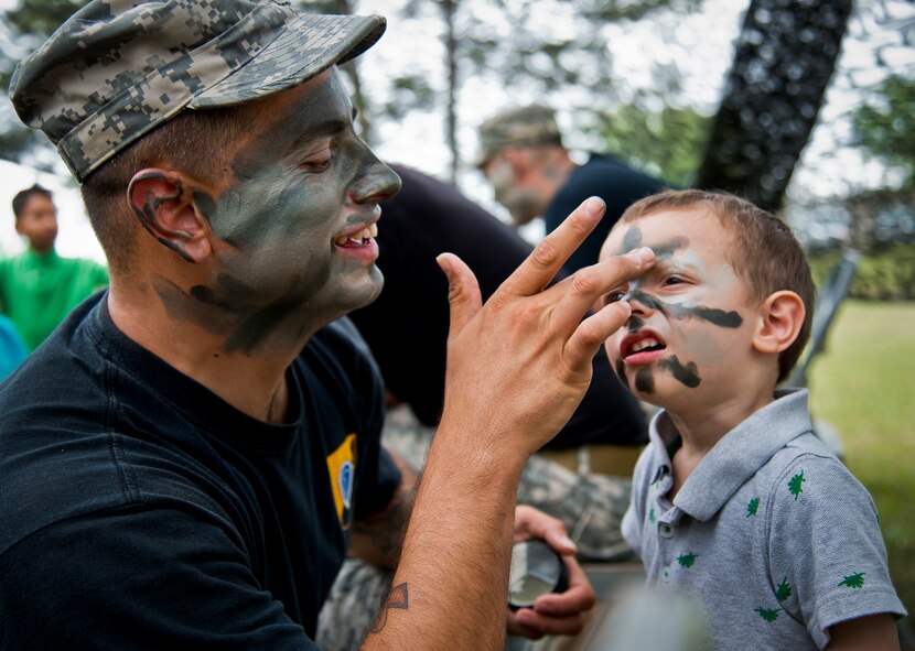 Spc. Youngs applies Ranger camouflage paint to two-year-old “soldier in training,” Miles Byrd, at the face-painting booth during the 6th Ranger Training Battalion’s Open House event May 10 at Eglin Air Force Base, Fla.  The event was a chance for the public to learn how Rangers train and operate. The event displays showed equipment, weapons, a reptile zoo, face painting and weapon firing among others. The demonstrations showed off hand-to-hand combat, a parachute jump, snake show, and Rangers in action.  (U.S. Air Force photo/Tech. Sgt. Sam King)