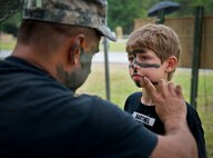 Spc. Youngs applies Ranger camouflage paint to a “soldier in training” at the face-painting booth during the 6th Ranger Training Battalion’s Open House event May 10 at Eglin Air Force Base, Fla.  The event was a chance for the public to learn how Rangers train and operate. The event displays showed equipment, weapons, a reptile zoo, face painting and weapon firing among others. The demonstrations showed off hand-to-hand combat, a parachute jump, snake show, and Rangers in action.  (U.S. Air Force photo/Tech. Sgt. Sam King)