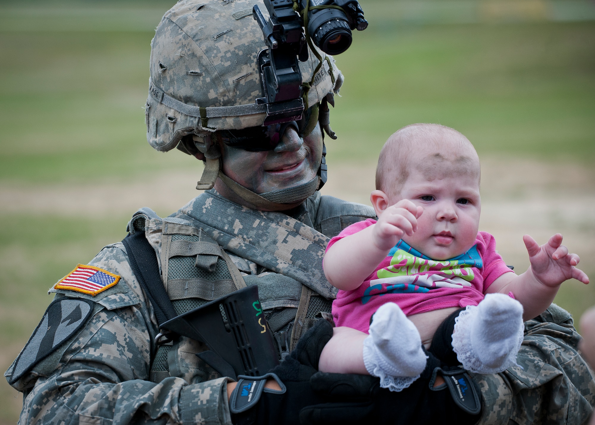 Sgt. Dennis White holds his daughter, Aris, after a “Rangers in Action” demonstration at the 6th Ranger Training Battalion’s Open House event May 10 at Eglin Air Force Base, Fla.  The event was a chance for the public to learn how Rangers train and operate. The event displays showed equipment, weapons, a reptile zoo, face painting and weapon firing among others. The demonstrations showed off hand-to-hand combat, a parachute jump, snake show, and Rangers in action.  (U.S. Air Force photo/Tech. Sgt. Sam King)