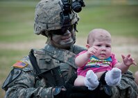 Sgt. Dennis White holds his daughter, Aris, after a “Rangers in Action” demonstration at the 6th Ranger Training Battalion’s Open House event May 10 at Eglin Air Force Base, Fla.  The event was a chance for the public to learn how Rangers train and operate. The event displays showed equipment, weapons, a reptile zoo, face painting and weapon firing among others. The demonstrations showed off hand-to-hand combat, a parachute jump, snake show, and Rangers in action.  (U.S. Air Force photo/Tech. Sgt. Sam King)