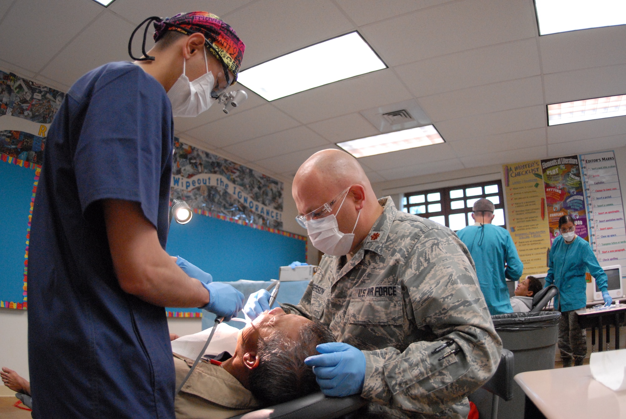 Oregon Air National Guard Maj. Paul Anderson, a 173rd Medical Group general dentist treats a dental patient at the Iao Intermediate School in Wailuku, Hawaii, June 9, 2013. Over 500 U.S. service members spread across Hawaii for Tropic Care 2013, an innovative readiness training exercise offering free health care to medically underserved areas of the state. (U.S. Air National Guard photo by Senior Airman Michael Quiboloy)