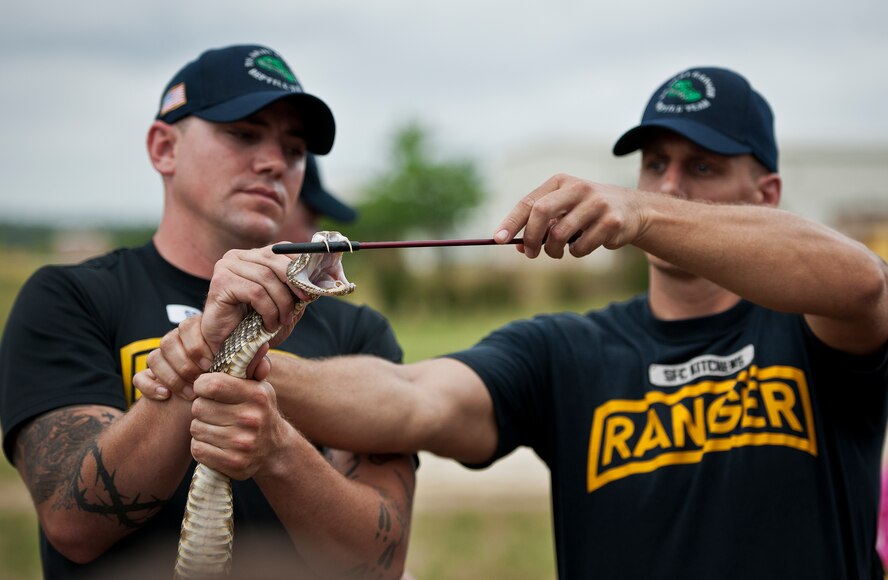 The 6th Ranger Training Battalion’s resident snake handlers show the fangs of poisonous snake to the crowd during the snake show demonstration at the Rangers’ Open House event May 10 at Eglin Air Force Base, Fla.  The event was a chance for the public to learn how Rangers train and operate. The event displays showed equipment, weapons, a reptile zoo, face painting and weapon firing among others. The demonstrations showed off hand-to-hand combat, a parachute jump, snake show, and Rangers in action.  (U.S. Air Force photo/Tech. Sgt. Sam King