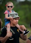 An Army specialist carries his daughter on his shoulders during the 6th Ranger Training Battalion’s Open House event May 10 at Eglin Air Force Base, Fla.  The event was a chance for the public to learn how Rangers train and operate. The event displays showed equipment, weapons, a reptile zoo, face painting and weapon firing among others. The demonstrations showed off hand-to-hand combat, a parachute jump, snake show, and Rangers in action.  (U.S. Air Force photo/Tech. Sgt. Sam King)
