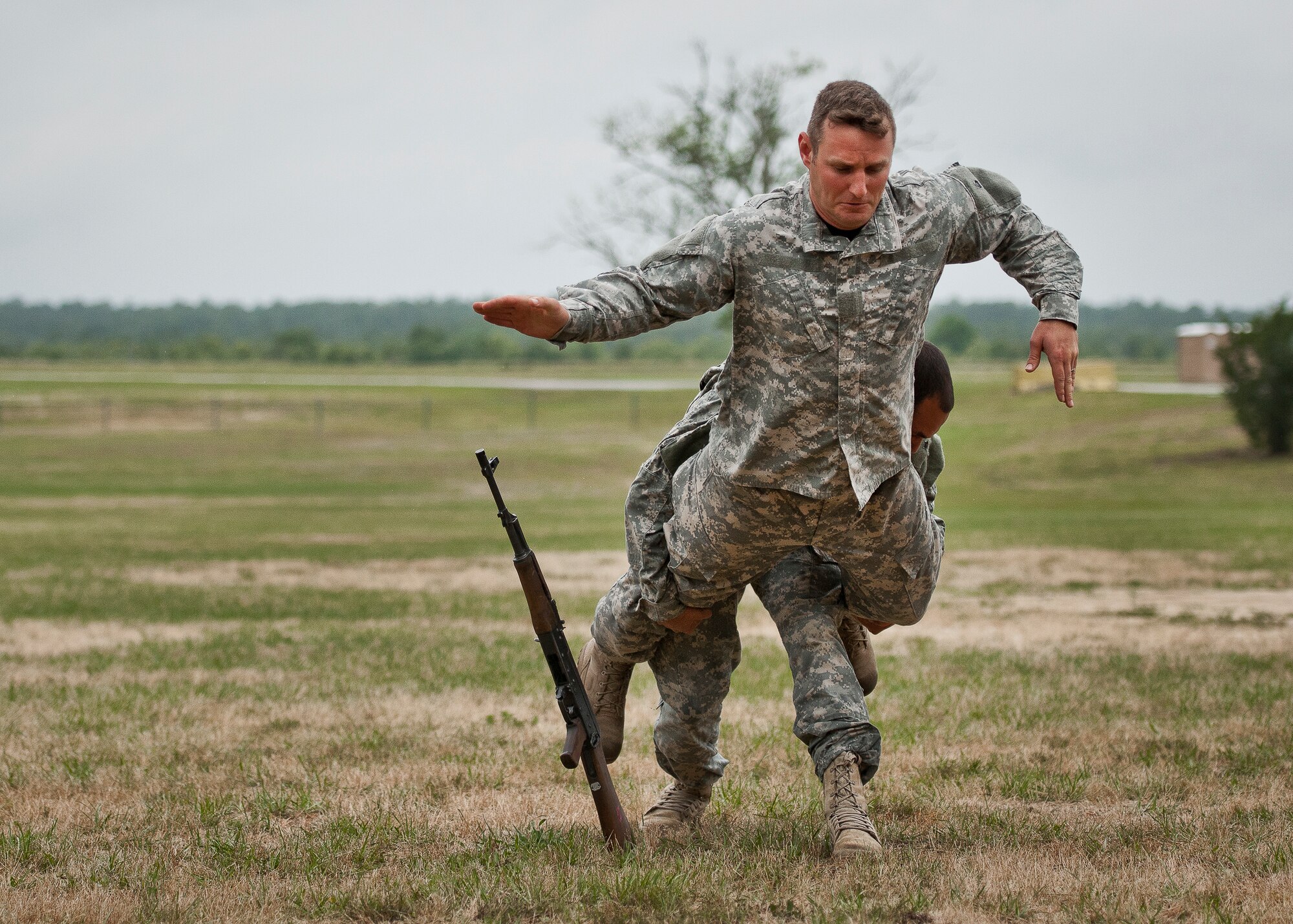 Staff Sgt. Ariel Rivera tackles Sgt. 1st Class Christian Bearden from behind during the hand-to-hand combat demonstration at the 6th Ranger Training Battalion’s Open House event May 10 at Eglin Air Force Base, Fla.  The event was a chance for the public to learn how Rangers train and operate. The event displays showed equipment, weapons, a reptile zoo, face painting and weapon firing among others. The demonstrations showed off hand-to-hand combat, a parachute jump, snake show, and Rangers in action.  (U.S. Air Force photo/Tech. Sgt. Sam King)
