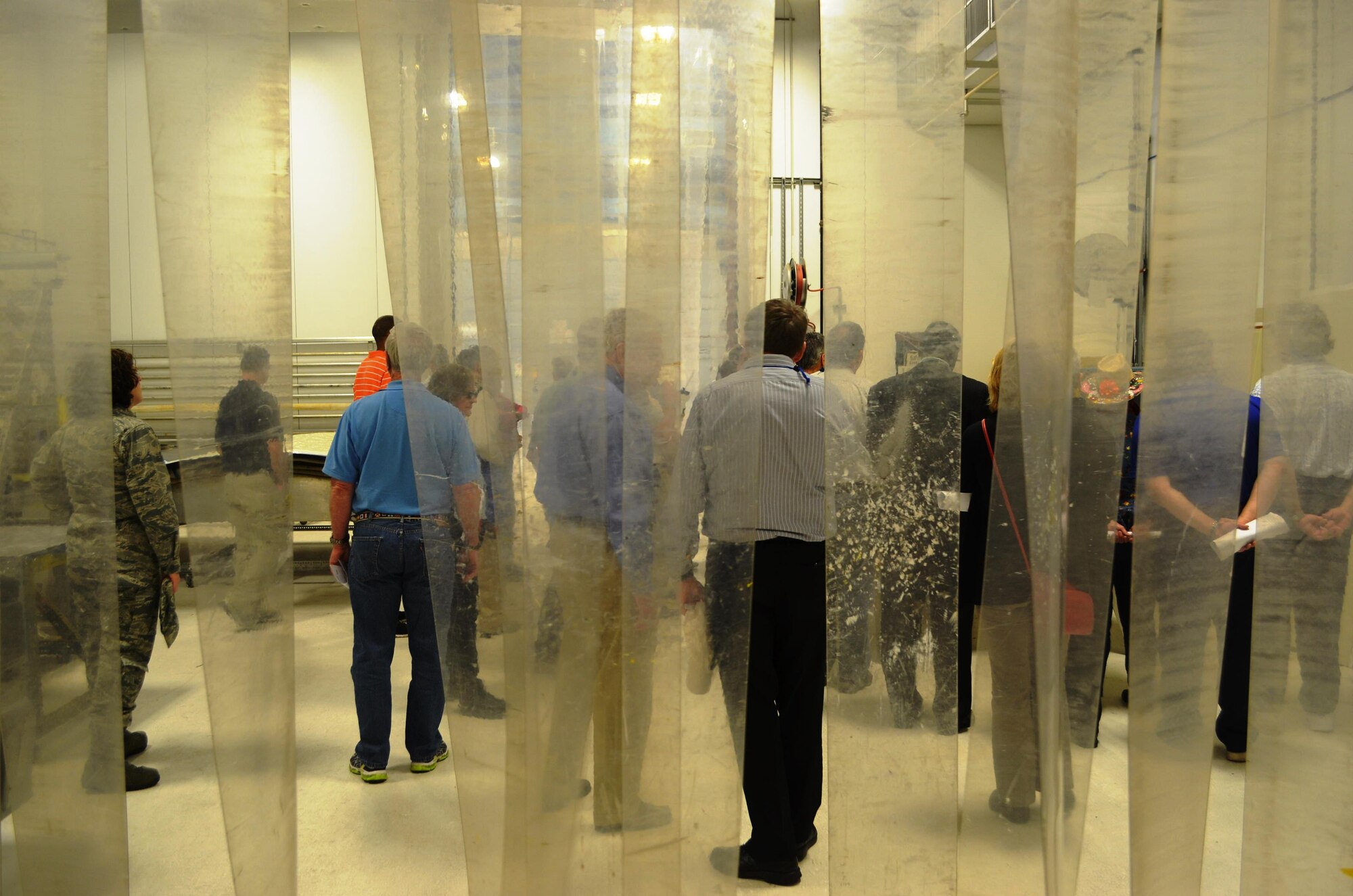 Occupational medicine physicians, attending an American Occupational Health Conference in San Antonio, work through a plastic barrier that separates the corrosion work shop from the bonding shop at the 433rd Maintenance Squadron’s corrosion control facility. Physicians got a firsthand look of the C-5A Galaxy aircraft and the special safety and hazardous challenges that the aircraft poses for aircraft maintainers, specifically corrosion control technicians. (U.S. Air Force photo/Senior Master Sgt. Minnie Jones)


