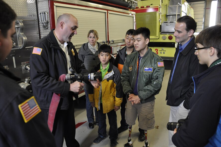 Fire Chief Wayne Wood shows Isaac Eun Soo French, Pilot for A Day, some of the equipment the Westover Fire Department uses during a tour of Westover on April A UTA. Isaac was born in South Korea and adopted by the French family when he was three years old. He was born without portions of bones in his lower legs and middle fingers. (photo by TSgt. Brian Boynton)