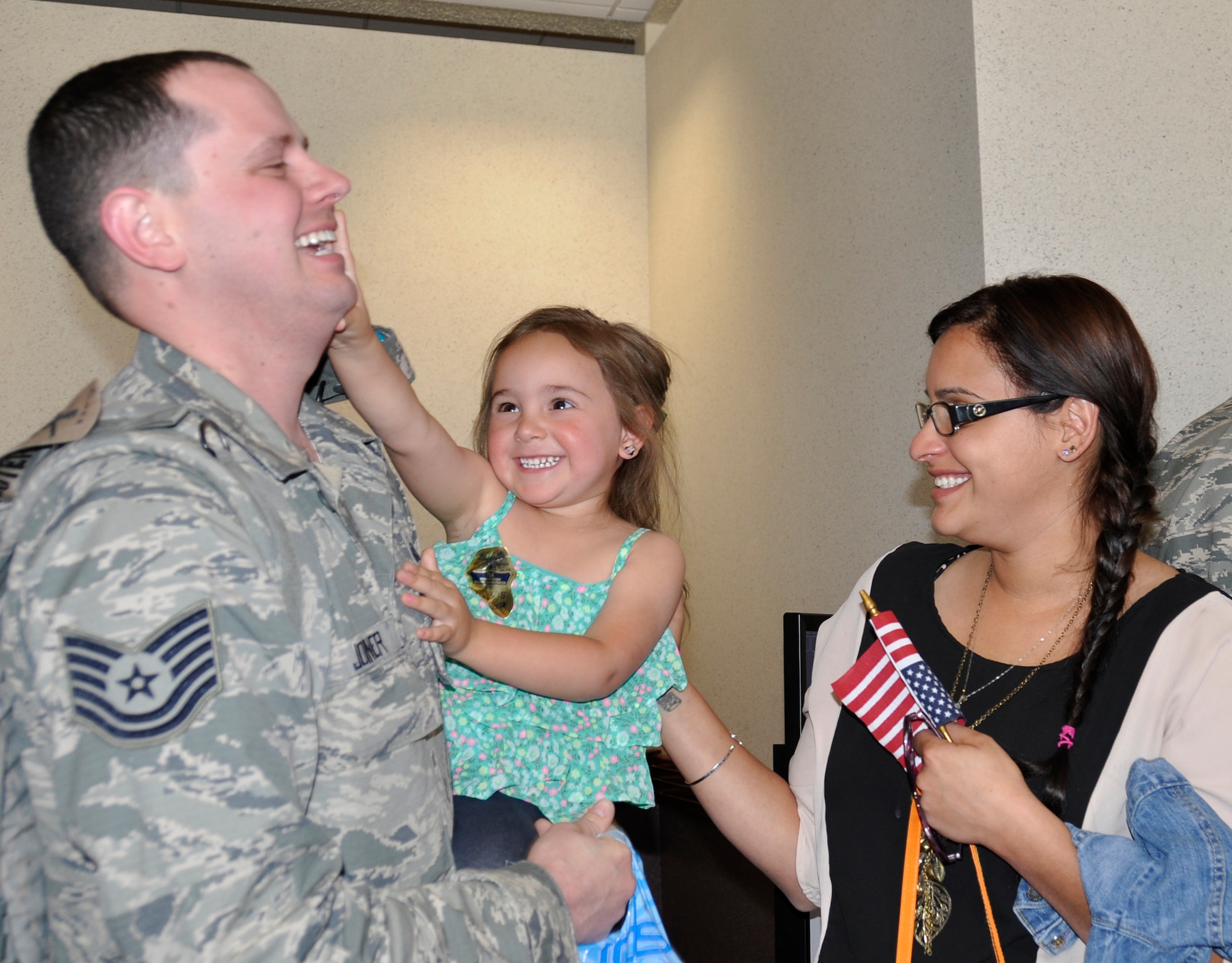 PETERSON AIR FORCE BASE, Colo. -Tech. Sgt. Scott Joiner, 302nd Security Forces Squadron, is greeted by his daughter Xadie and wife Carmen upon his redeployment May 3, 2014. Joiner returned to Colorado Springs with nearly 30 security forces members from the Air Force Reserve Command’s 302nd Airlift Wing, located here, and the 310th Space Wing, located at Schriever Air Force Base, Colo. The Airmen were deployed to the Transit Center at Manas, Kyrgyz Republic since Jan. 15. While deployed, the Airmen provided for the location's integrated base defense systems. They also provided for the Center's physical security as well as its antiterrorism and force protection measures. Joiner is a fire team leader for the security forces squadron. (U.S. Air Force photo/Maj. Corinna Moylan)
