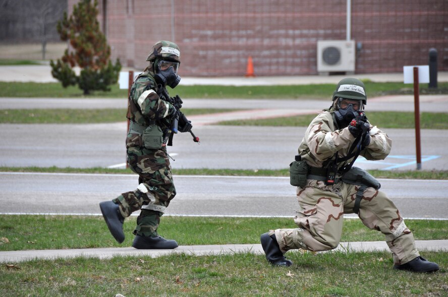 Staff Sergeants Scott Robinson (right) and Felix Ramirez, 927th Communications Squadron, search for injuries, casualties, and unexploded ordinance following a simulated chemical attack at Alpena CRTC.  The 50 member team received valuable training on mission essential tasks and operating in a chemical environment. (U.S. Air Force photo by Capt. Joe Simms)