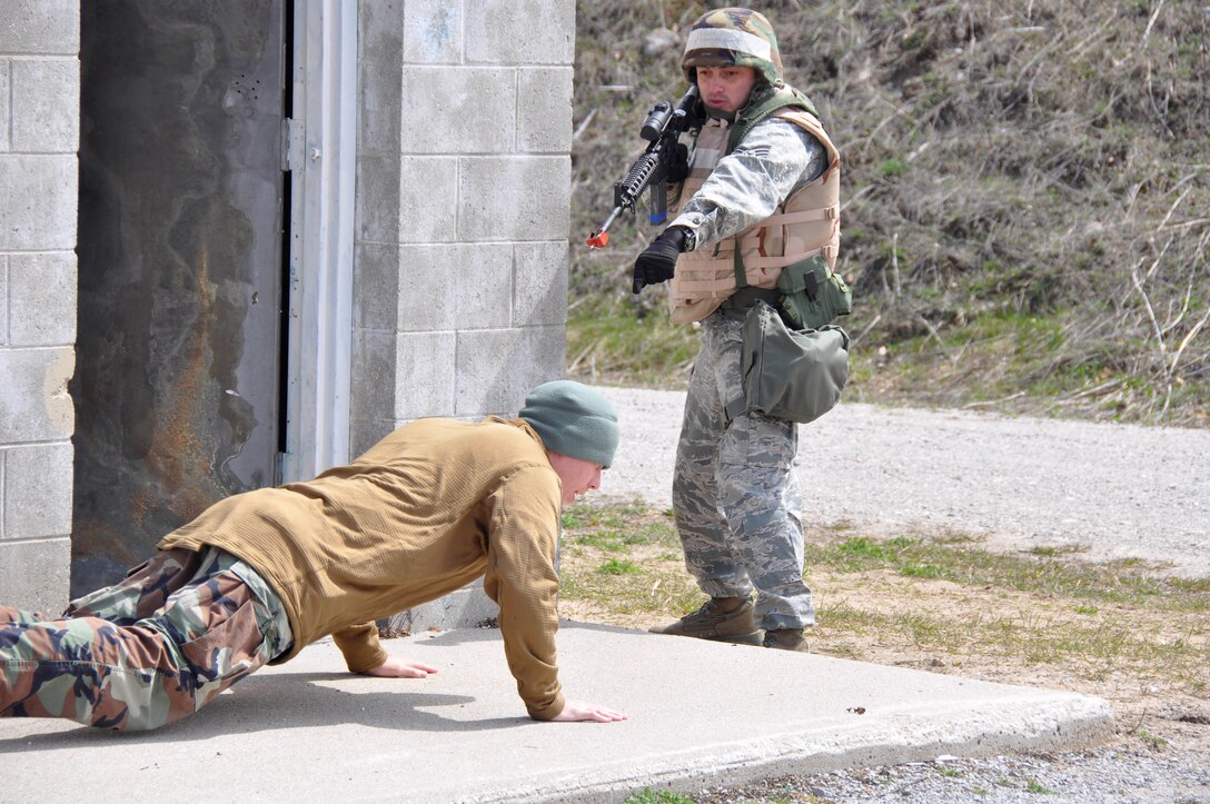 Staff Sergeant Geanny Hernandez, 927th Logistics Readiness Squadron, directs a member of the opposing forces team to the ground during a training scenario at the Alpena CRTC, May 7. The scenario called for members of a convoy to react when they encounter hostile forces at their destination. (U.S. Air Force Photo by Capt Joe Simms)